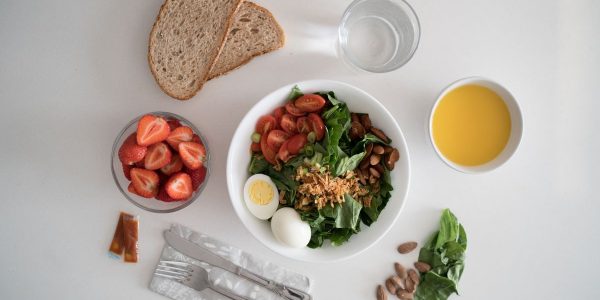Top view of a nutritious breakfast with salad, eggs, bread, and juice, perfect for a healthy start.